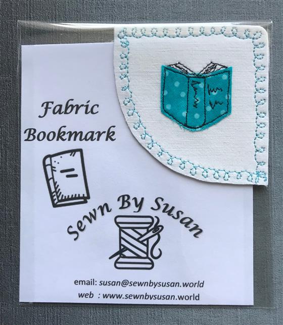 corner bookmark - blue book on white fabric