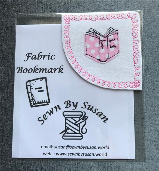 corner bookmark - pink book on white fabric